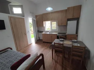 a kitchen with a table and chairs and a kitchen with a counter at Lenio's Apartment in Souda