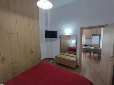 a bedroom with a bed and a dining room at Lenio's Apartment in Souda