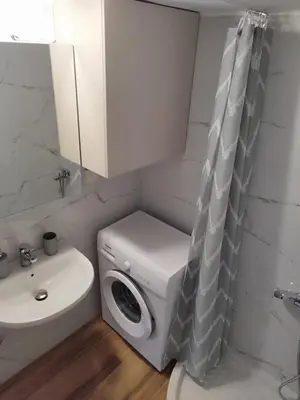 a bathroom with a washing machine next to a sink at Lenio's Apartment in Souda