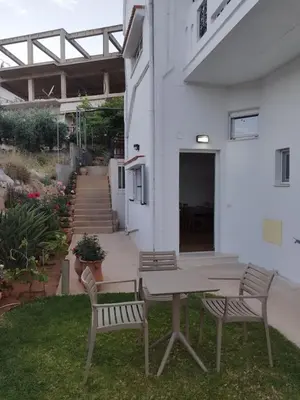 a table and two chairs in a yard at Lenio's Apartment in Souda