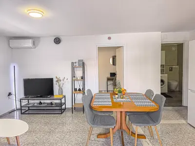 a living room with a table and chairs and a television at Comfy flat with large terrace, Fiber internet and private parking in Chania Town