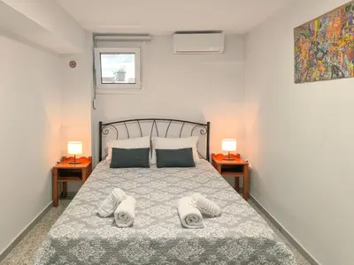 a bedroom with a bed with two lamps on two tables at Comfy flat with large terrace, Fiber internet and private parking in Chania Town