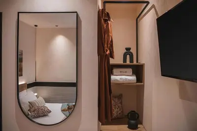 a mirror on a wall with a bed in a room at Mimosa Minaret Jacuzzi Old Town Chania in Chania Town
