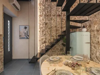 a dining room with a table and a refrigerator at Mimosa Minaret Jacuzzi Old Town Chania in Chania Town