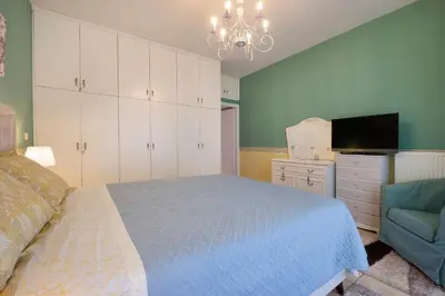 a bedroom with a bed and a tv and a chair at Purple Apartment Chania in Chania Town