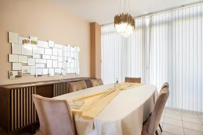 a dining room with a white table and a chandelier at Purple Apartment Chania in Chania Town