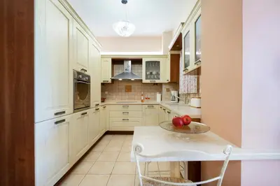 a kitchen with white cabinets and a table with apples on it at Purple Apartment Chania in Chania Town
