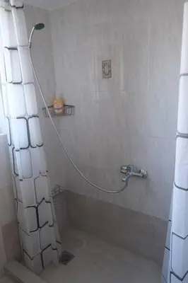 a shower with a hose in a bathroom at Bayside Apt. in Souda