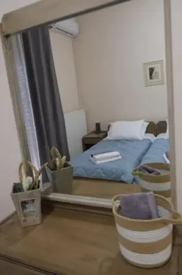 a mirror on a table with a bed in a bedroom at Bayside Apt. in Souda