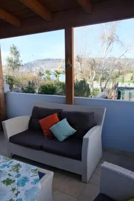 a couch with two pillows sitting on a balcony at Bayside Apt. in Souda