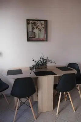 a table with chairs and a potted plant on it at Bayside Apt. in Souda