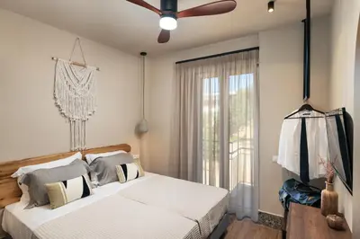 a bedroom with a bed and a ceiling fan at Raviewha Luxury Apartments in Ravdhoúkha