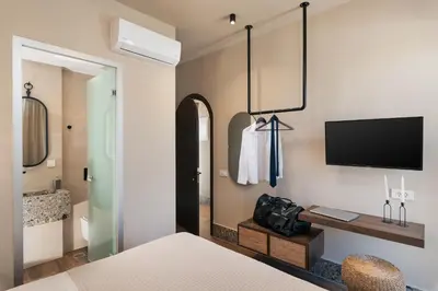 a bedroom with a bed and a tv on a wall at Raviewha Luxury Apartments in Ravdhoúkha
