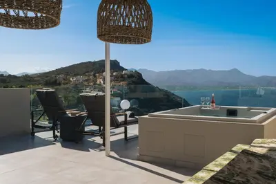 a patio with a tub and a table and chairs at Raviewha Luxury Apartments in Ravdhoúkha