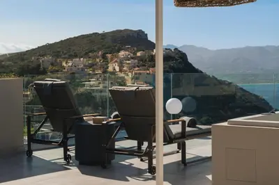 a kitchen with two chairs and a view of a mountain at Raviewha Luxury Apartments in Ravdhoúkha