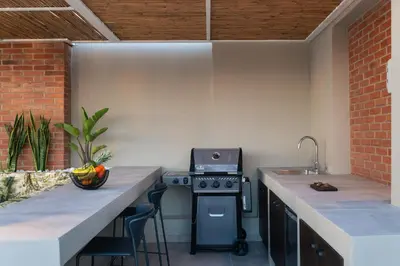a kitchen with a stove and a counter with chairs at Raviewha Luxury Apartments in Ravdhoúkha
