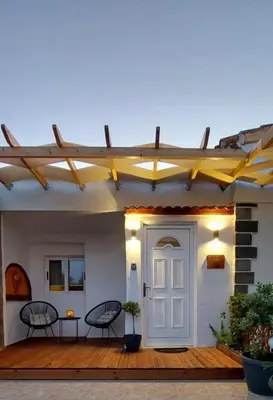 a patio with two chairs and a white door at The Nook in Maleme