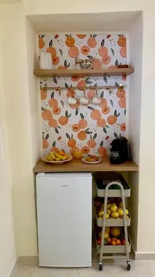 a small kitchen with a shelf with plates of food at The Nook in Maleme