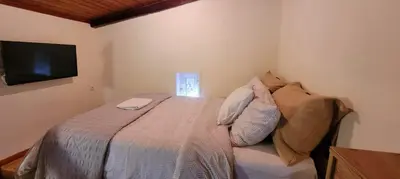 a bedroom with a bed with a tv on the wall at The Nook in Maleme