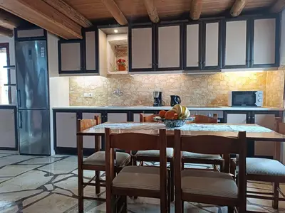 a kitchen with a table with chairs and a counter at Villa Lina private pool in Kondomari