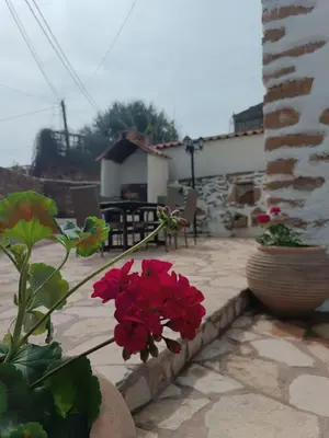 a patio with red flowers in vases next to a building at Villa Lina private pool in Kondomari