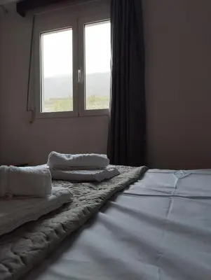 a bedroom with two beds and a window at Votsalo House in Khóra Sfakíon