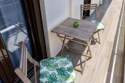 a small table and a chair on a balcony at Kyril Apartment in Chania Town