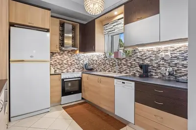 a kitchen with wooden cabinets and a stone wall at CasaParadiso in Perivólia