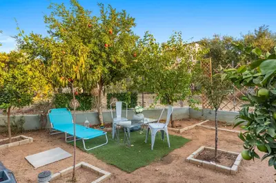 two chairs and a table under an apple tree at CasaParadiso in Perivólia