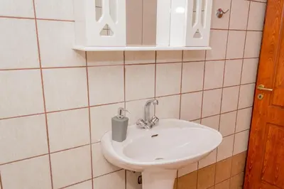 a bathroom with a sink and a mirror at Olivia House -BY APOKORNAS VILLAS in Káïna