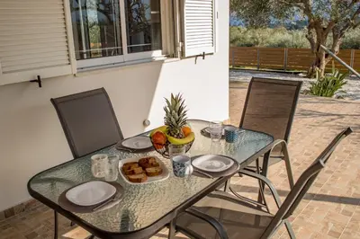 a glass table with a plate of food on it at Olivia House -BY APOKORNAS VILLAS in Káïna