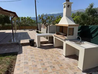 a kitchen with a sink and a lighthouse on a patio at Olivia House -BY APOKORNAS VILLAS in Káïna