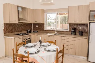 a kitchen with a table with a white table cloth at Olivia House -BY APOKORNAS VILLAS in Káïna