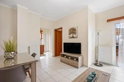 a living room with a television and a table at Sofie's Garden View Apartment in Daratso