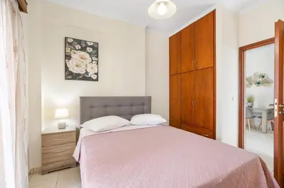a bedroom with a bed and a dresser and a table at Sofie's Garden View Apartment in Daratso