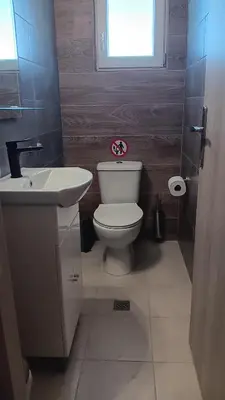 a bathroom with a toilet and a sink and a window at NICOL's HOUSE in Chania Town