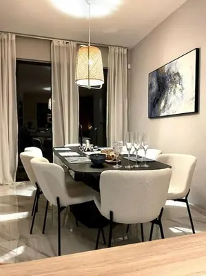 a dining room with a table with white chairs and a dining room at Luxury Sunset Villa with Private Pool & Sea Views in Kalyves