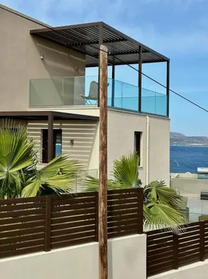 a house with a wooden fence and a pole at Luxury Sunset Villa with Private Pool & Sea Views in Kalyves