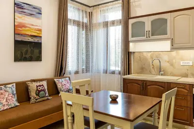 a kitchen and a living room with a table and a couch at The Owl House near Chania City Centre in Chania Town