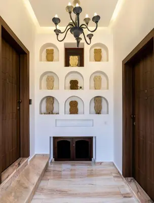 a living room with a fireplace and a chandelier at The Owl House near Chania City Centre in Chania Town
