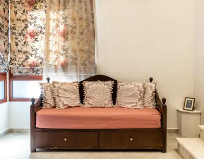 a bed with pillows in a room with a window at The Owl House near Chania City Centre in Chania Town