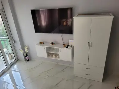 a living room with a white cabinet and a flat screen tv at Cretan Dream in Chania Town