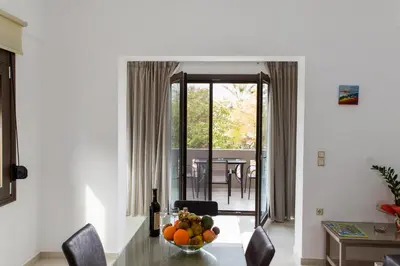 a dining room with a table with a bowl of fruit at Angela Apartments in Kato Daratso