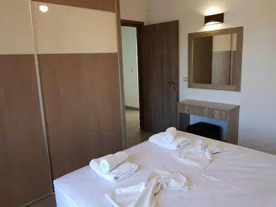 a bedroom with a bed with towels on it at Angela Apartments in Kato Daratso