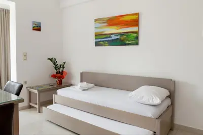 a bedroom with a bed and a painting on the wall at Angela Apartments in Kato Daratso