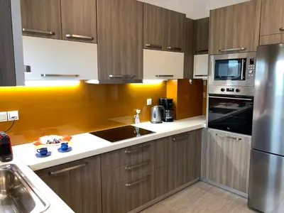 a kitchen with wooden cabinets and a stainless steel refrigerator at Angela Apartments in Kato Daratso
