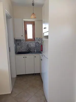 a kitchen with white cabinets and a sink at Aspro Apartments in Koprána