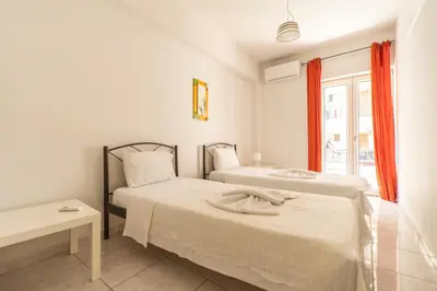 two beds in a white room with a window at Dimitris City Break Apts in Chania Town
