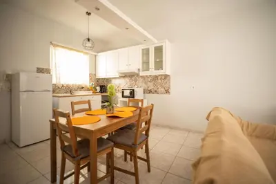 a kitchen with a table and chairs and a refrigerator at Dimitris City Break Apts in Chania Town