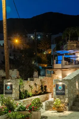 a building with a sign that reads vikitas at night at VENTUS Luxury Suites in Khóra Sfakíon